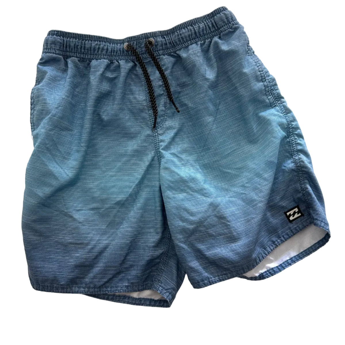 A pair of boy's light blue denim swim trunks with a black drawstring and a small black brand patch, laid flat on a white fabric background.