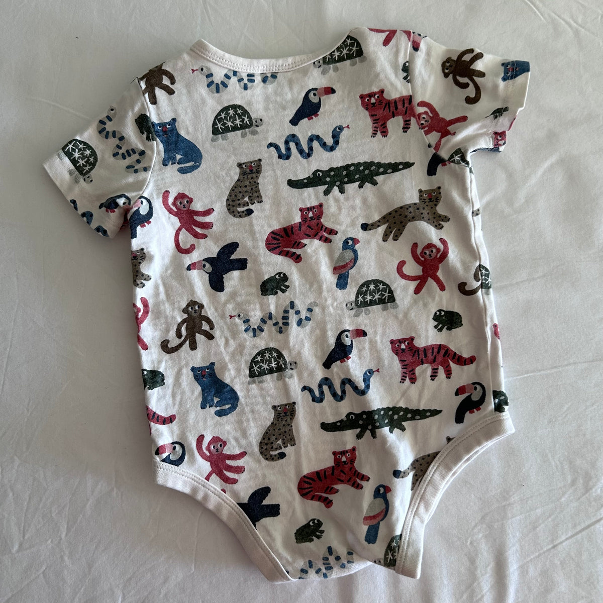 Target Age 0 short sleeve bodysuit in white, multicolour with allover jungle animal print (tigers, monkeys, toucans, crocodiles, snakes, turtles, leopards) — like new condition.