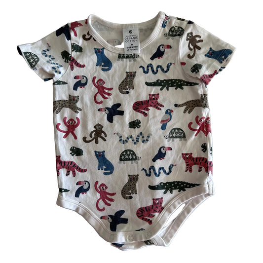 A baby short-sleeve bodysuit with an all-over animal print, laid flat on a white fabric background. The bodysuit features a white base with colorful illustrations of various animals including monkeys, birds, snakes, and cats in red, blue, brown, and black.