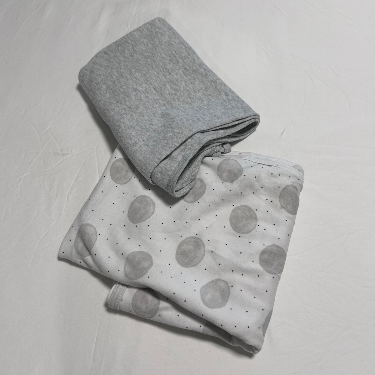 Dymples 000, 00, 0 - ideal for a range of ages swaddle in white, grey with large grey watercolour spots with small black dots on sheet; plain grey on second piece — gently loved condition.