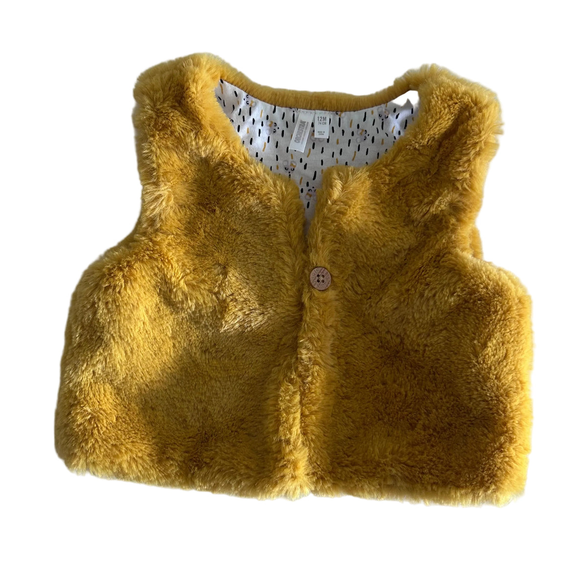 Orchestra Age 1 faux fur sleeveless gilet vest in mustard yellow with plain faux fur exterior, printed lining with black and mustard dash/raindrop pattern and small animal motifs — like new condition.