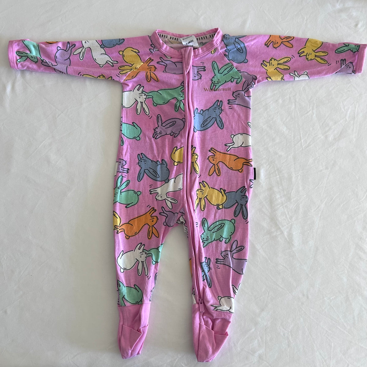 Bonds Age 00 long sleeved zip onesie / wondersuit in pink with multicoloured bunny rabbit all-over print â€” gently loved condition.
