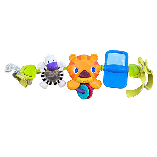 A colorful baby sensory pram toy with a zebra, orange tiger, blue rectangular piece, and green banana-shaped pieces attached to a central handle, laid flat.