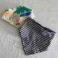 Halcyon Nights + One Other 00 bandana bib set (2 bibs) in cream, teal, yellow, pink, blue, navy, white with crocodile and abstract shapes print on one bib; navy and white stripes on reverse — gently loved condition.