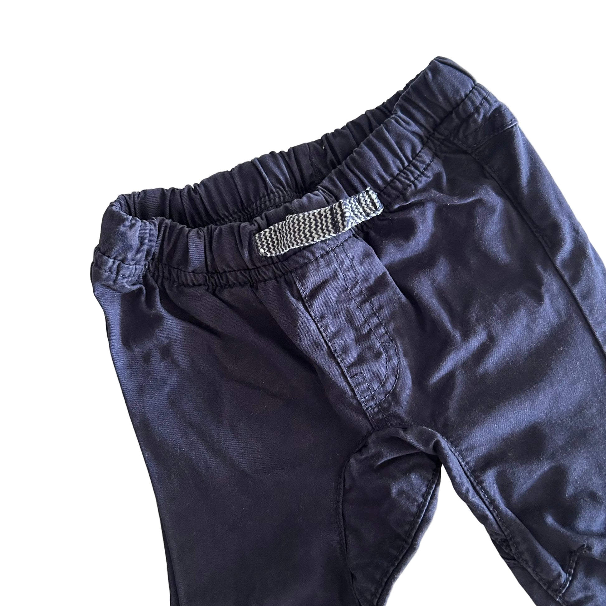 Dark blue trousers with a textured elastic on a light background