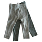 Two pairs of green themed baby leggings on a light surface