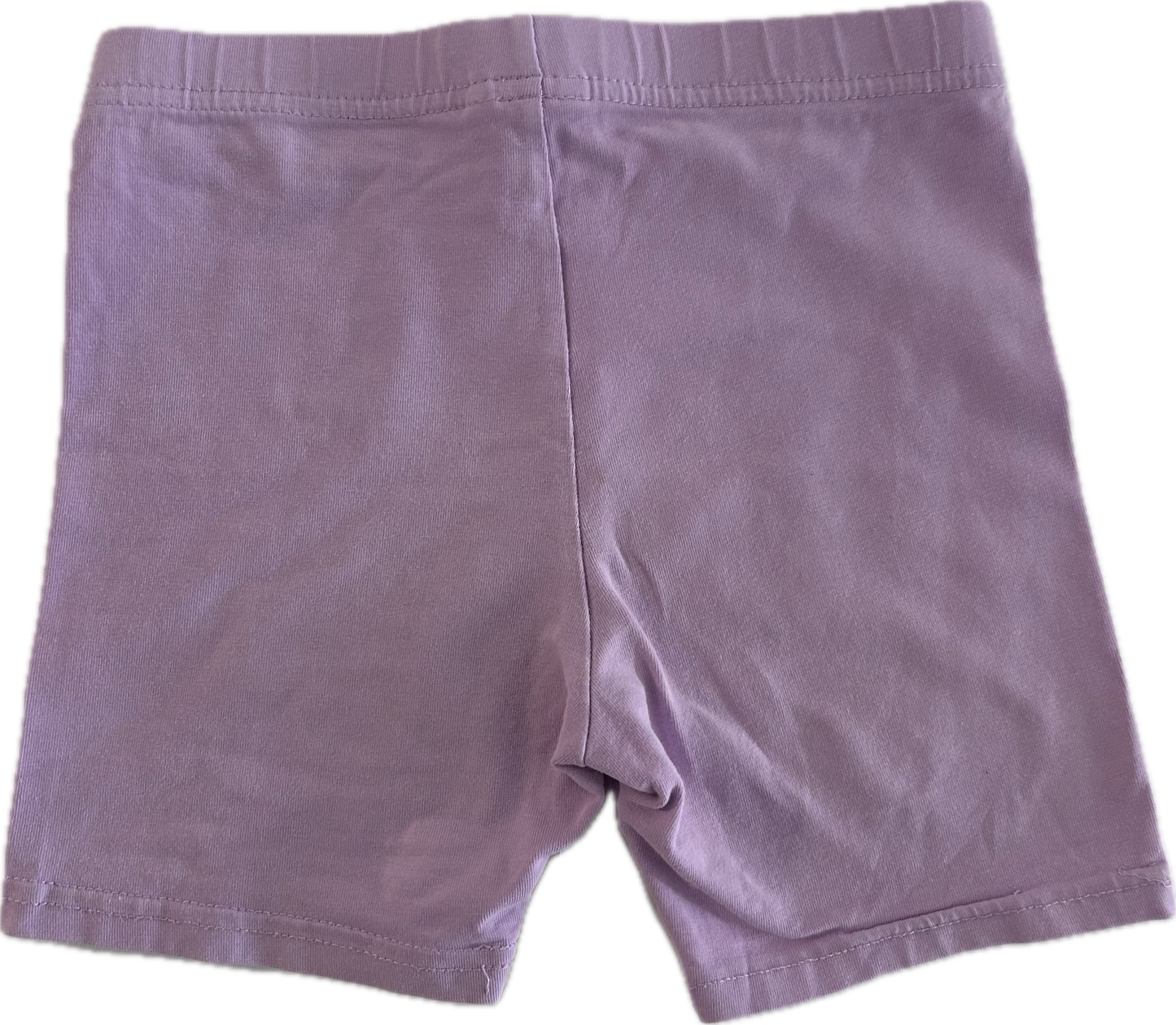 Lilac children's shorts on pale background