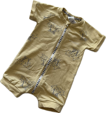 Mustard yellow baby romper with short sleeves and palm tree pattern on pale background