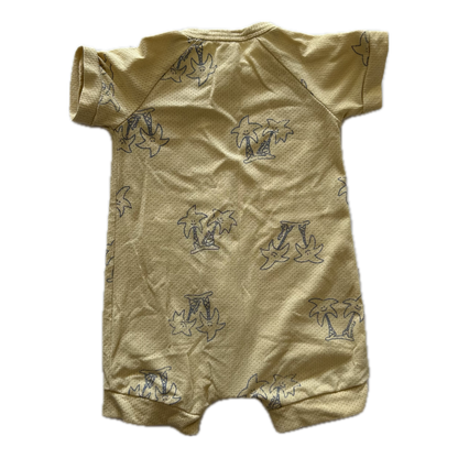 Mustard yellow baby romper with short sleeves and palm tree pattern on pale background