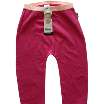 A pair of infant leggings in a bright pink color, featuring a contrasting light pink waistband and a hanging Bonds brand tag