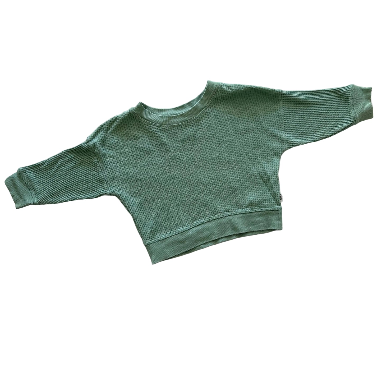 A green waffle knit style long-sleeve jumper laid flat on a white background.