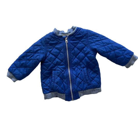 A blue quilted children's jacket with gray ribbed trim, laid flat on a white background.