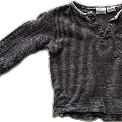 A dark gray-brown ribbed knit long-sleeve shirt with a three-button placket and a chest pocket, laid flat against a white background.