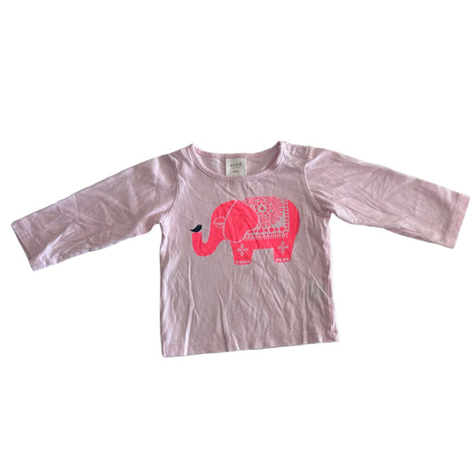 A long-sleeve t-shirt in light pink, featuring a bright pink elephant graphic on the front with a small black bird on its nose. The shirt is laid flat on a white background.