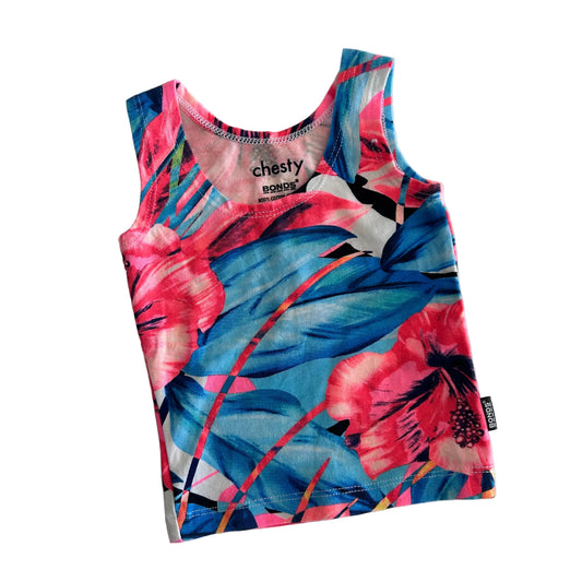 A sleeveless tank top with a vibrant tropical floral print in pink, blue, and white, laid flat on a white background. The brand name 'chesty' is visible on the inner neck label.