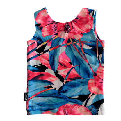 A sleeveless tank top with a vibrant tropical floral and leaf print in pink, blue, and white, laid flat on a light gray background. A small black fabric tag on the bottom left reads 'chesty'.