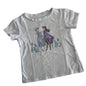 A white short-sleeve kids' t-shirt featuring a printed graphic of Elsa and Anna from Frozen holding hands, surrounded by small watercolor flowers, laid flat on a light background.