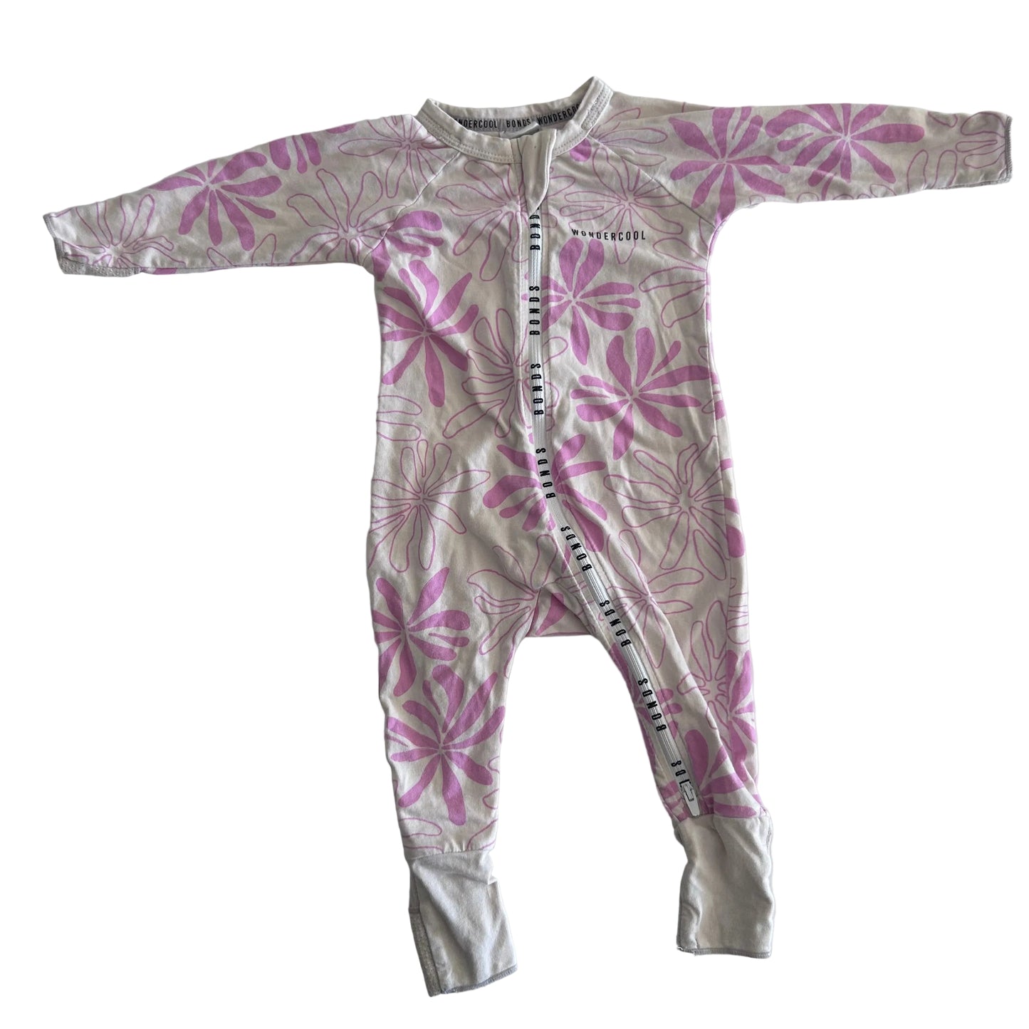 The front of a light pink baby onesie with long sleeves and legs, featuring a darker pink floral pattern, laid flat on a white surface.