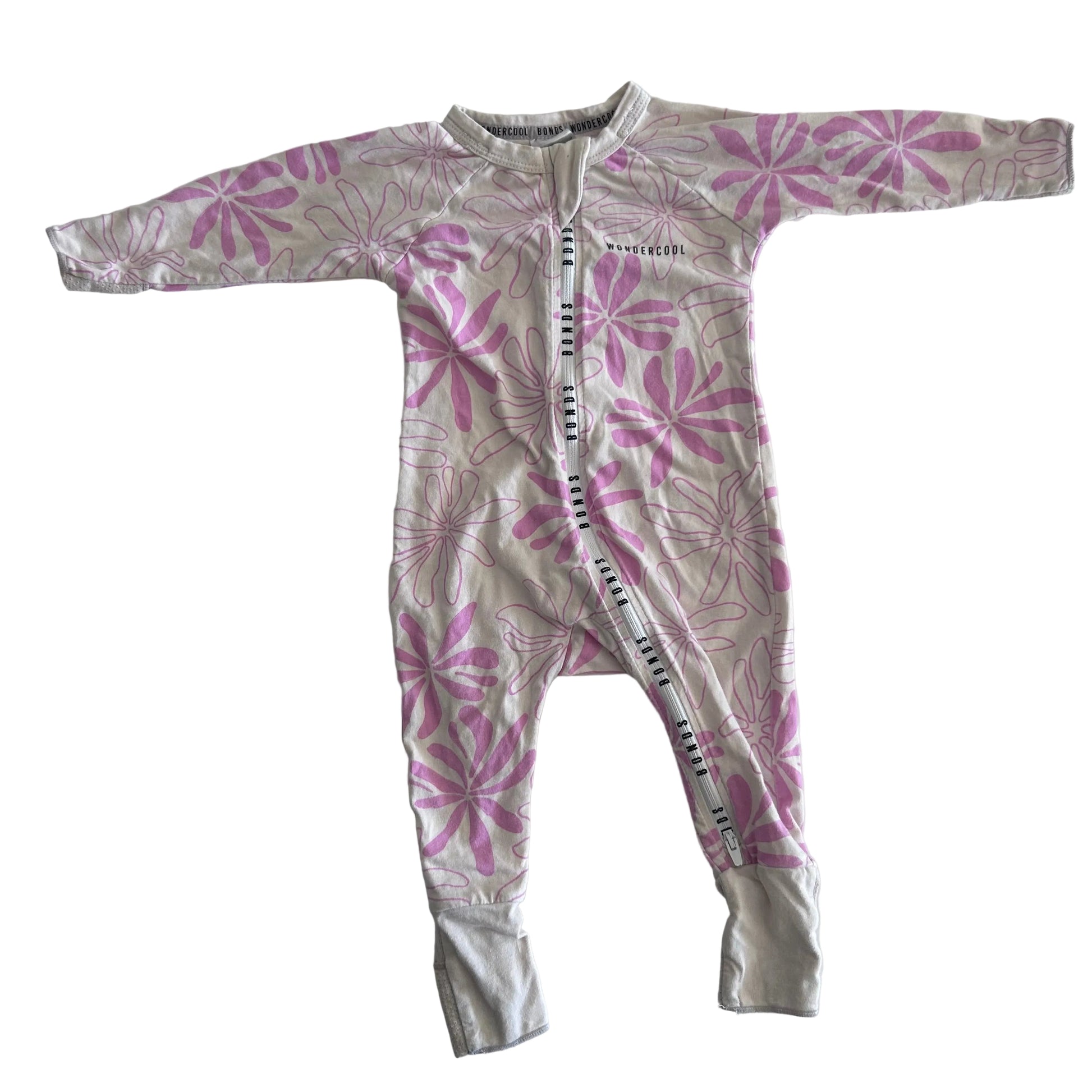 The front of a light pink baby onesie with long sleeves and legs, featuring a darker pink floral pattern, laid flat on a white surface.