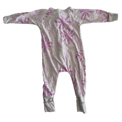 The back of a light pink baby onesie with long sleeves and legs, featuring a darker pink floral pattern, laid flat on a white surface.