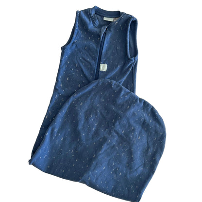 A baby sleep sack in navy blue with a subtle white speckled pattern, featuring a front zipper and a matching folded footed pillow, laid flat on a light background.