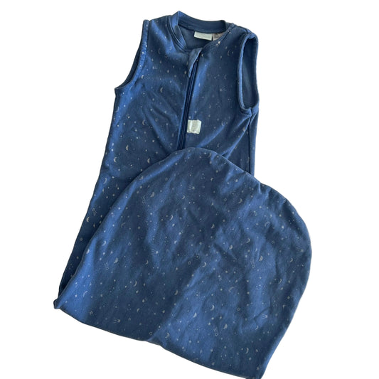 A baby sleep sack in navy blue with a subtle white speckled pattern, featuring a front zipper and a matching folded footed pillow, laid flat on a light background.