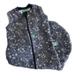 A sleeveless quilted sleeping bag laid flat on a white background, featuring a dark gray and navy blue space-themed print with stars, moons, and a white-and-black tic-tac-toe pattern. 