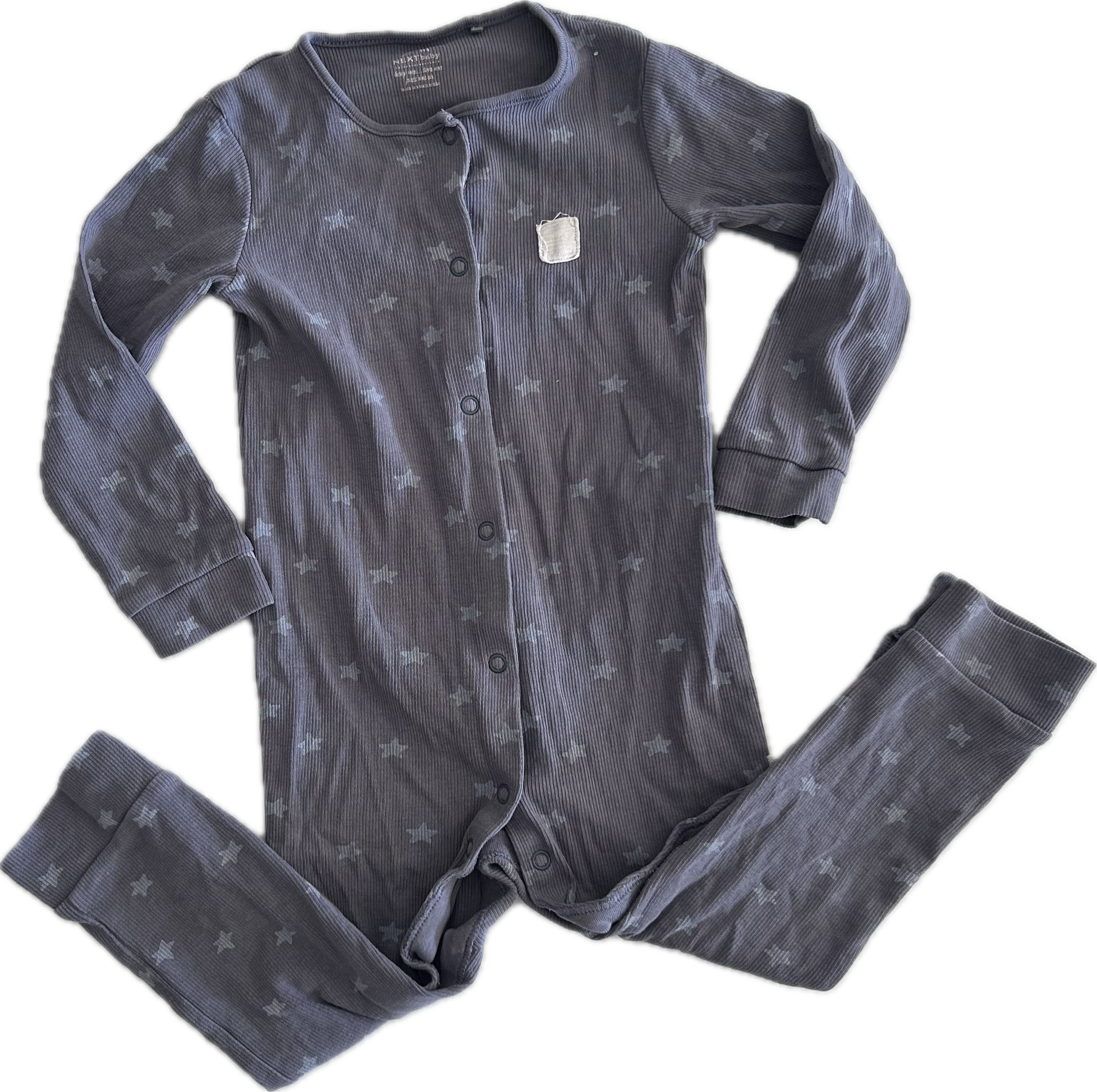 A button up onesie laid flat on a white background, featuring long sleeves, legs folder upwards, purple grey colour and stars and crescent moon pattern.