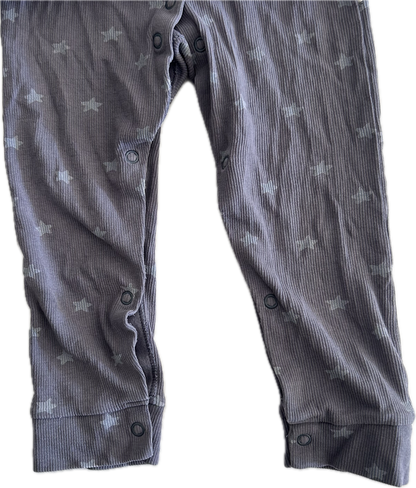 Close up photo of the legs of a purple-grey baby onesie with button up legs. 
