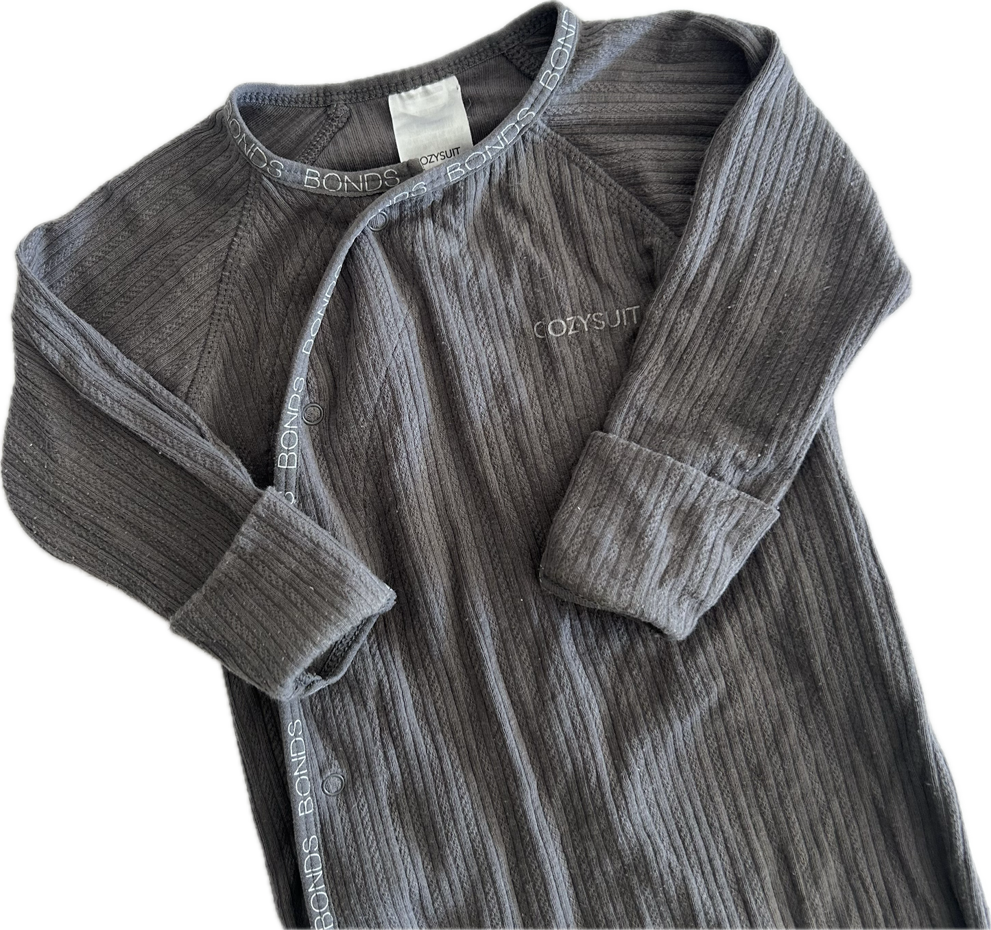 The top half of a dark gray ribbed long-sleeve baby onesie, featuring a snap-button front and a small white embroidered 'Cozysuit' logo on the chest, laid flat on a white background.