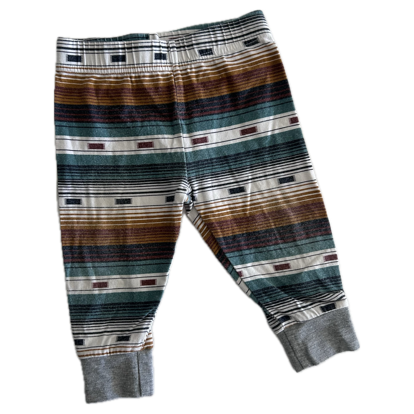 The front of pair of children's striped trousers with horizontal bands of brown, green, grey, black, and white, featuring ribbed ankle cuffs.