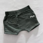 A pair of dark olive green FILA shorts with a white logo on the side, laid flat on a white fabric background.