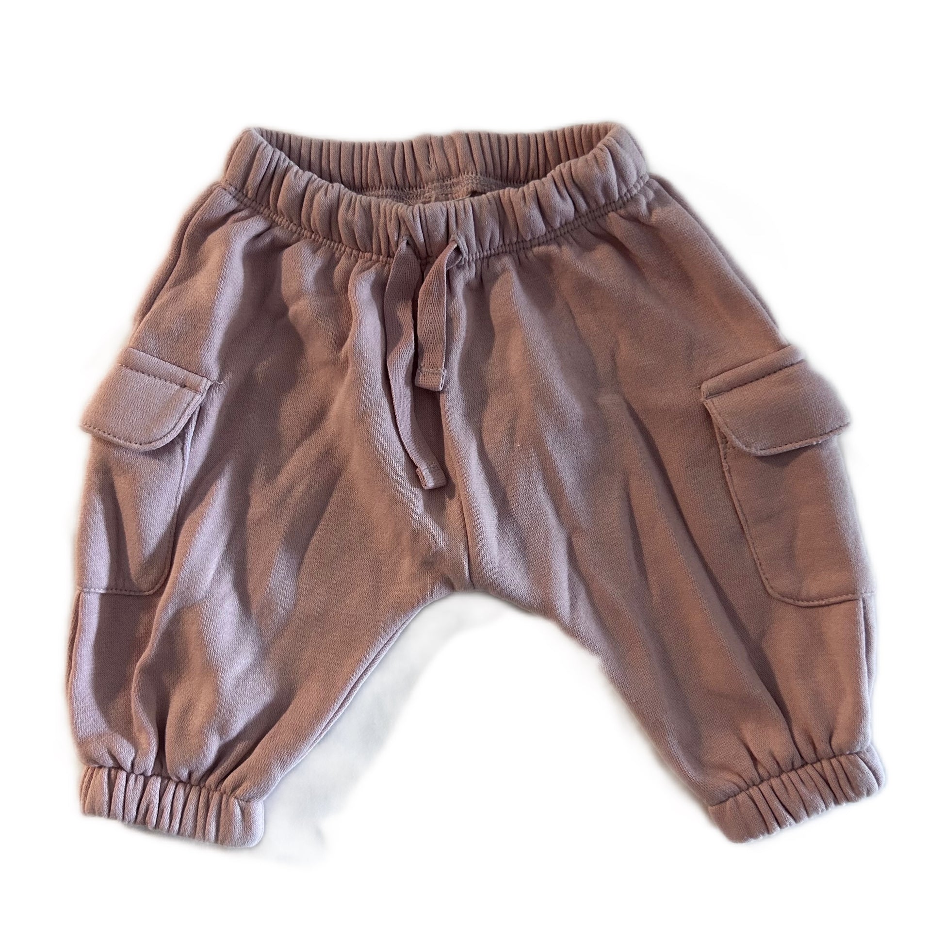 A pair of dusty brown harem-style cargo pants for toddlers, featuring an elastic waistband with a drawstring, side cargo pockets, and elastic cuffs, laid flat on a white background.
