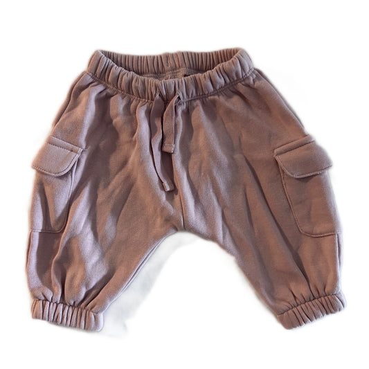 A pair of dusty brown harem-style cargo pants for toddlers, featuring an elastic waistband with a drawstring, side cargo pockets, and elastic cuffs, laid flat on a white background.