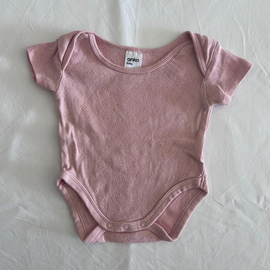 Anko Age 000 short sleeve snap-crotch bodysuit in pink with pointelle diamond knit texture â€” gently loved condition.
