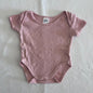 Anko Age 000 short sleeve snap-crotch bodysuit in pink with pointelle diamond knit texture â€” gently loved condition.