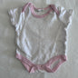 Bonjour BÃ©bÃ© Age 000 short sleeve snap-crotch bodysuit in white and pink with pink polka dots with pink trim â€” gently loved condition.