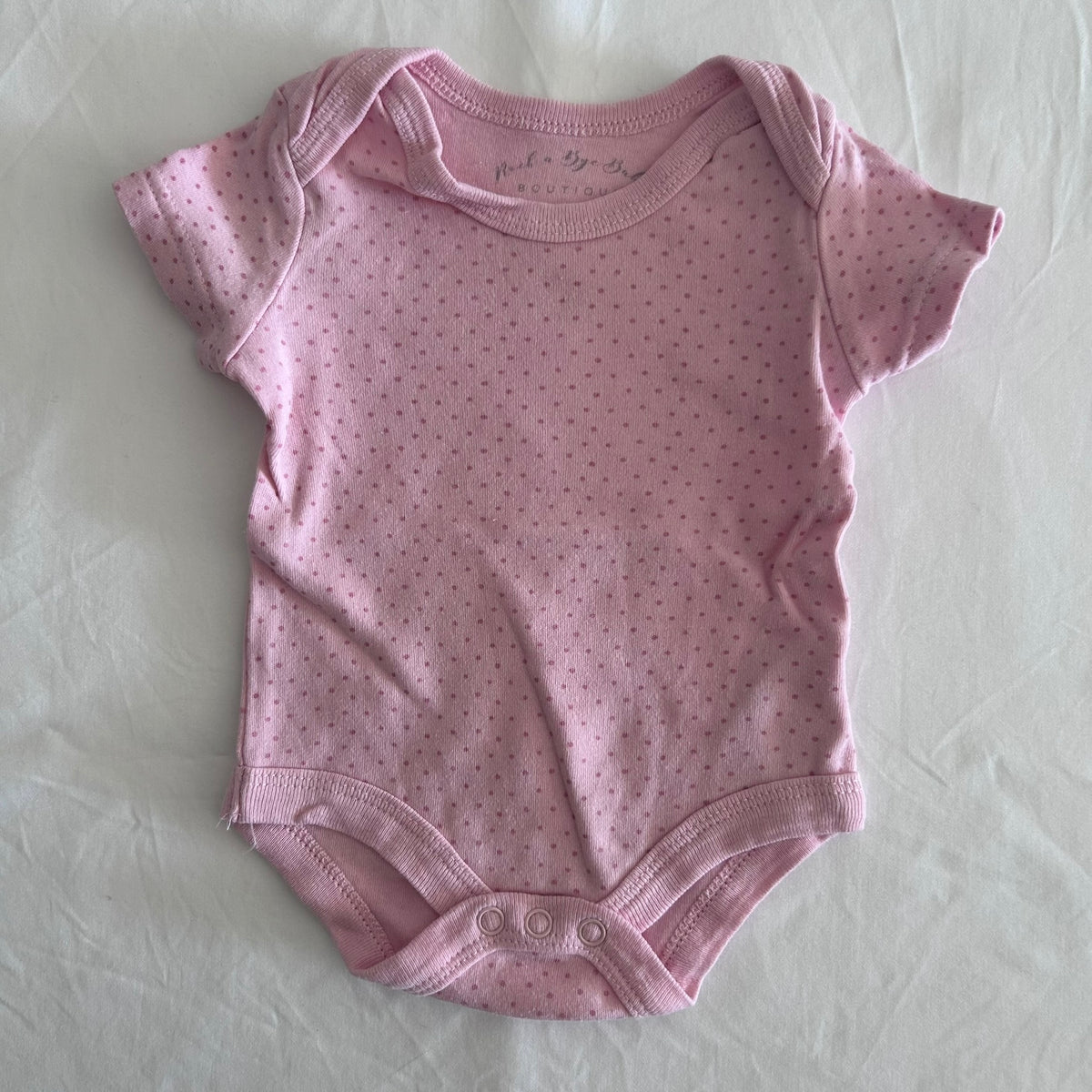 Rock-a-Bye Baby Boutique Age 000 short sleeve bodysuit in pink with polka dot â€” gently loved condition.