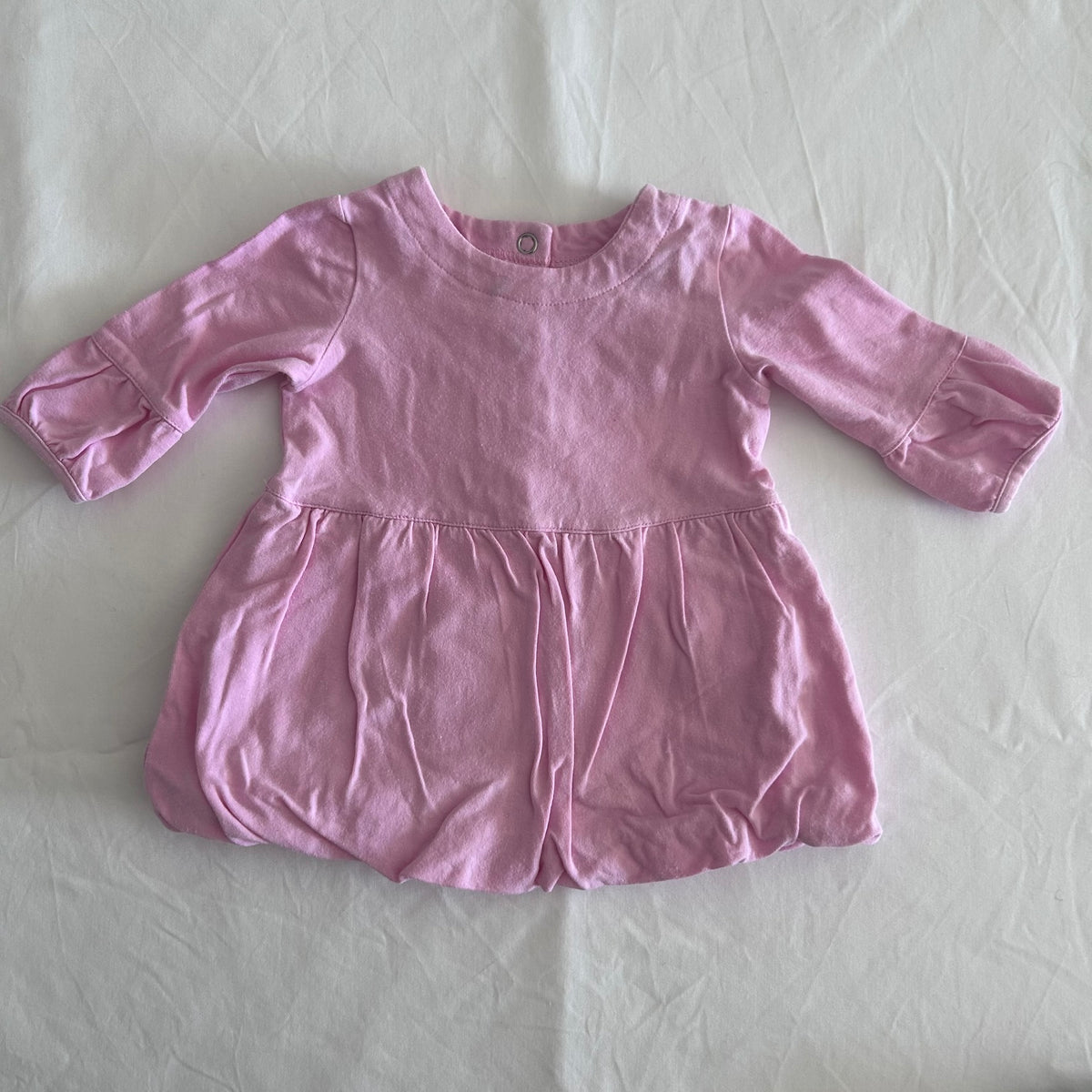 Sprout Age 000 long sleeve bubble dress in pink with plain with gathered skirt, ruffle cuffs, and back snap button placket â€” gently loved condition.