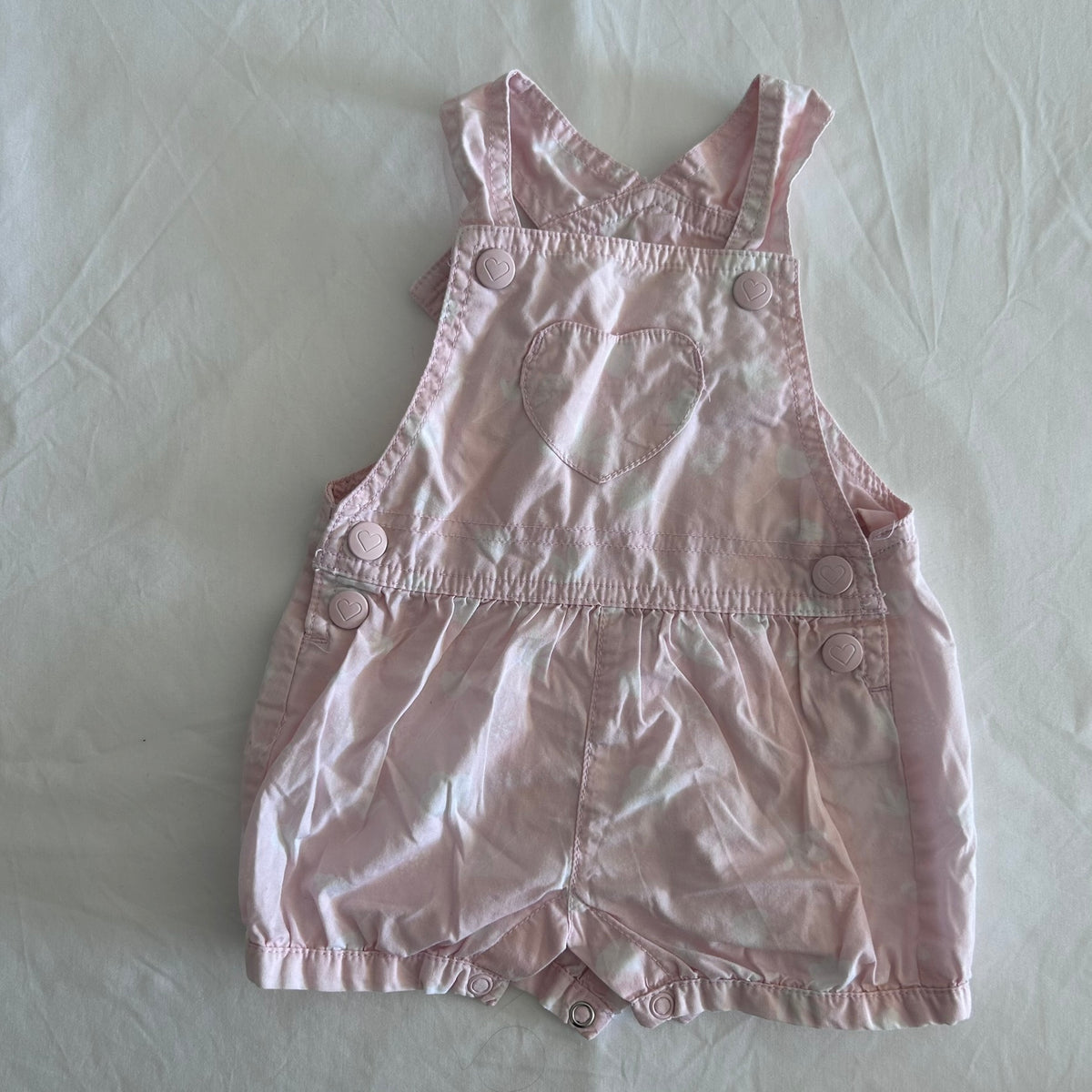 Kids & Co Age 000 sleeveless dungaree romper playsuit in light pink with tie-dye, heart-shaped chest pocket, heart-shaped snap buttons â€” gently loved condition.
