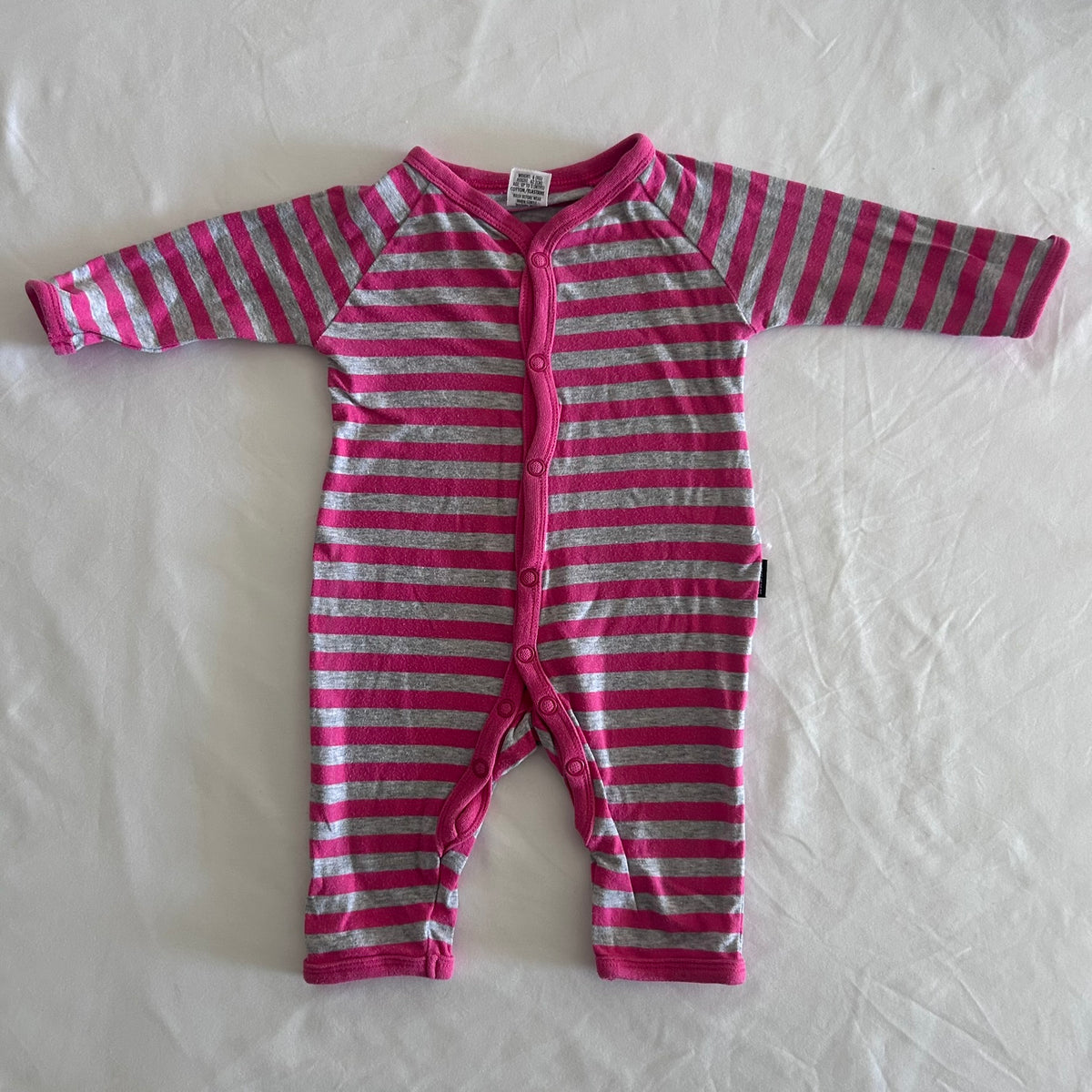 Bonds Age 000 long sleeve snap button onesie in pink, grey with horizontal stripes â€” gently loved condition.