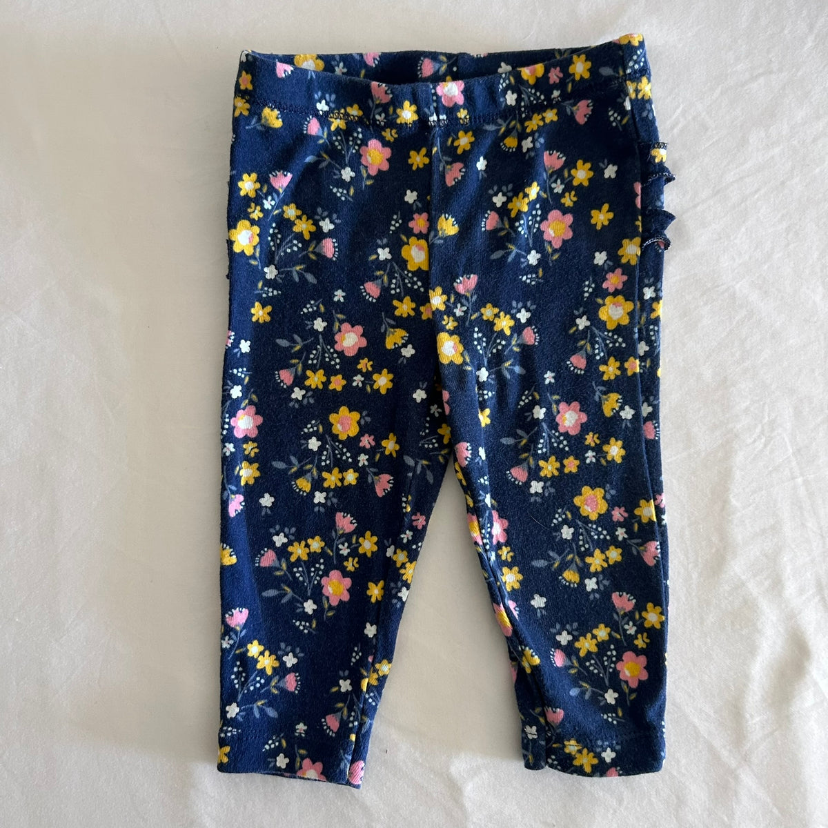 Carter's Age 0 leggings / trousers in navy blue, yellow, pink, white with floral print with ruffle trim detail â€” gently loved condition.