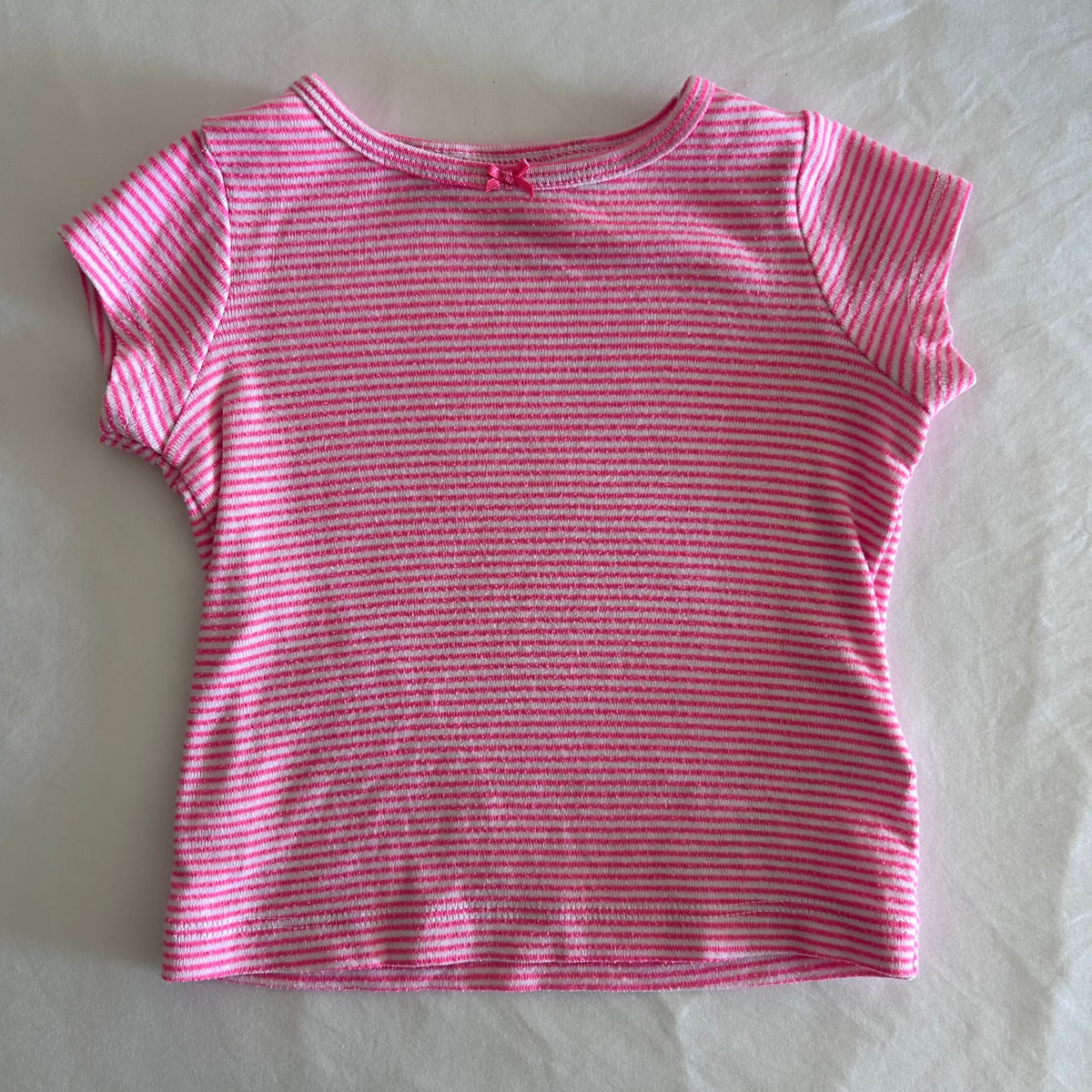 Carter's Age 0 short sleeve t-shirt in pink and white with horizontal stripes, small pink bow at neckline â€” gently loved condition.