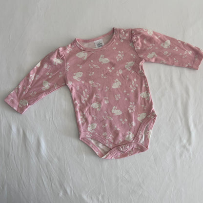 Ollie's Place Age 00 long sleeved bodysuit in pink with allover white bunny and floral print, gently loved condition.