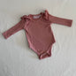La Sienna Couture Age 00 long sleeve ruffle shoulder bodysuit in dusty pink/mauve with ribbed texture with ruffle shoulder detail, gently loved condition.