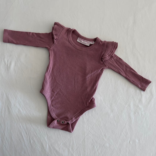 La Sienna Couture Age 00 long sleeve ribbed bodysuit with frill shoulder detail in dusty rose pink with ribbed texture with decorative frill at shoulders, gently loved condition.