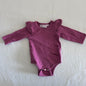 La Sienna Couture Age 00 long sleeved ruffle shoulder bodysuit in berry/magenta pink with ruffle detail at shoulders, gently loved condition.