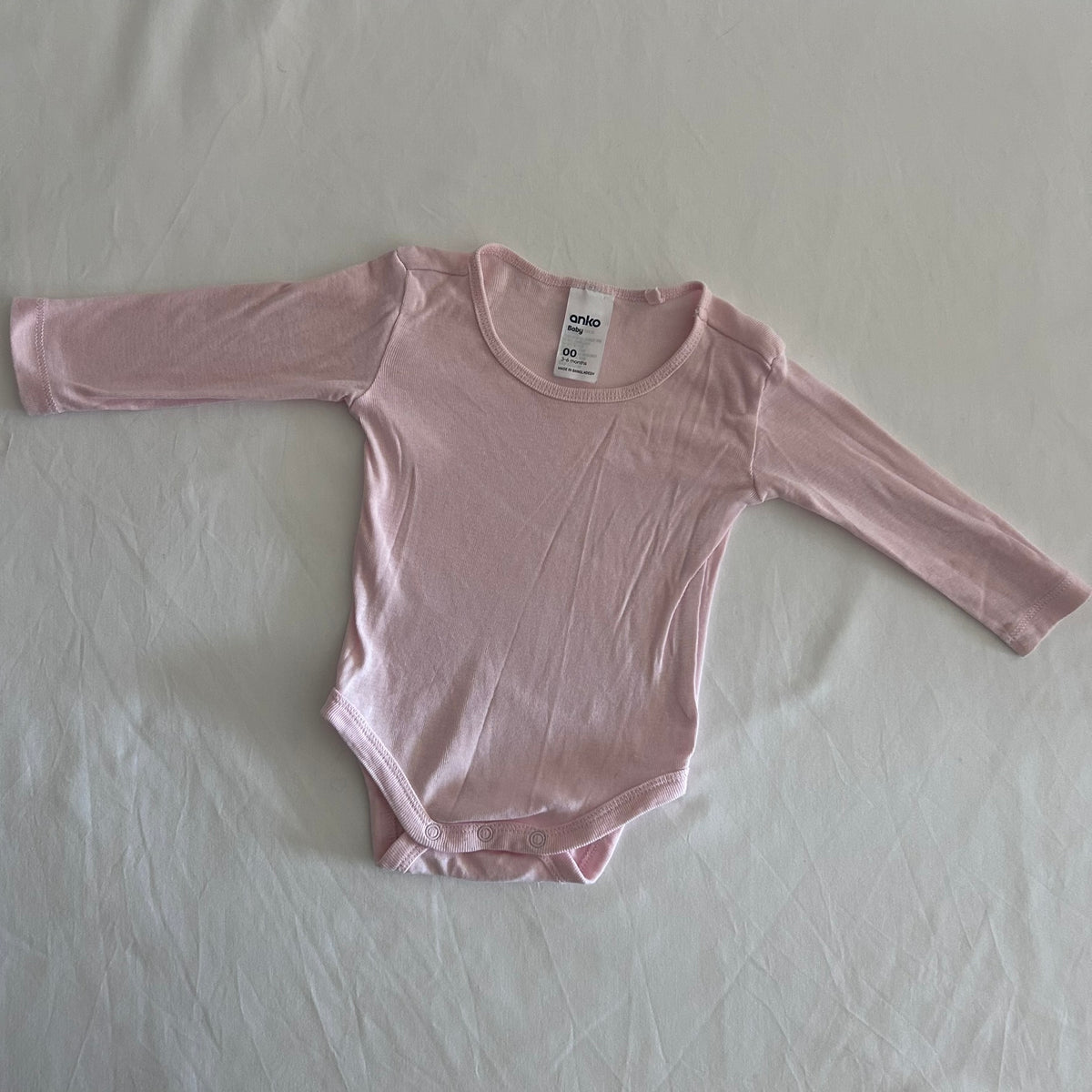 Anko Age 00 long sleeve bodysuit in pink with plain, gently loved condition.