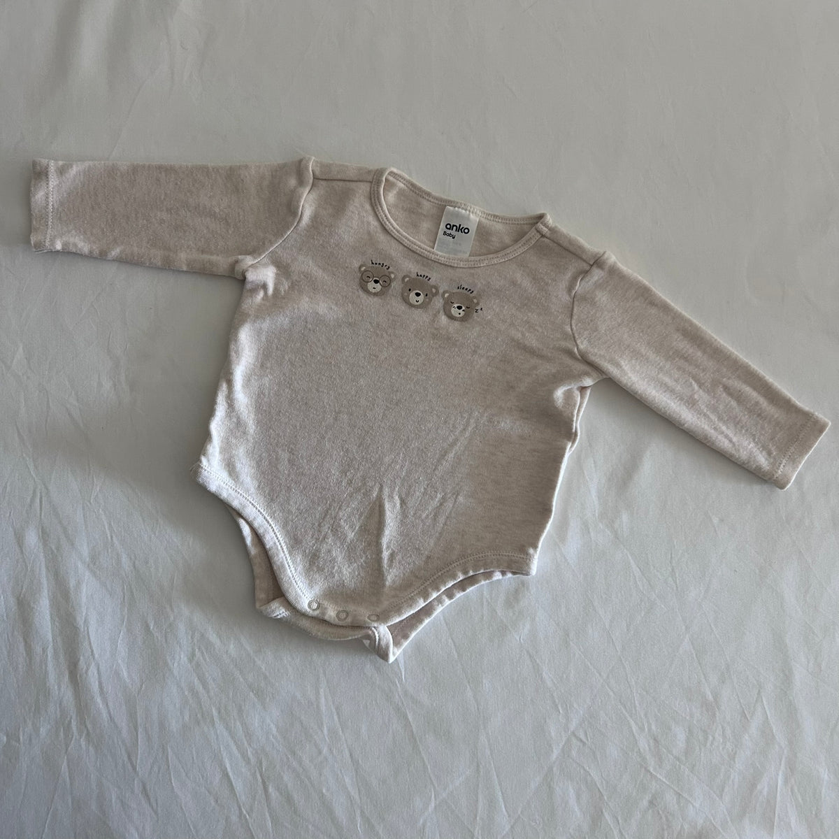 Anko Age 00 long sleeved bodysuit in oatmeal/cream with three printed teddy bear faces labelled hungry, happy, sleepy, gently loved condition.