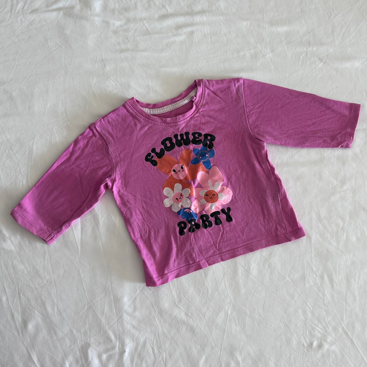 Mango Age 1 long sleeved tee in pink with glitter/foil cartoon flower graphic with text 'flower party' — well loved condition.